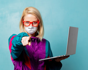 Style blonde woman in 90s clothes and face mask holds notebook