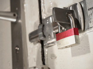 A bolted door secured by a padlock with the national flag of Indonesia on it.(series)