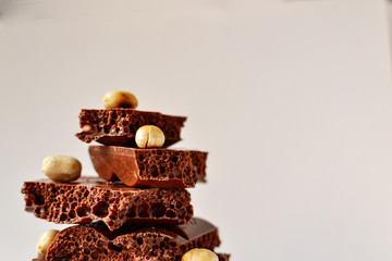 Chocolate on a white background, isolated. Porous chocolate with nuts, texture, close-up