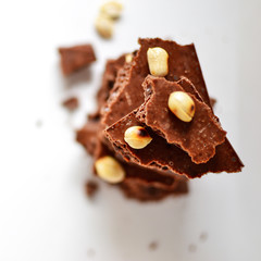 Chocolate on a white background, isolated. Porous chocolate with nuts, texture, close-up