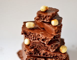 Chocolate on a white background, isolated. Porous chocolate with nuts, texture, close-up