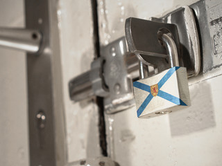 A bolted door secured by a padlock with the national flag of Nova Scotia on it.(series)
