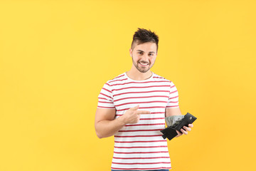 Happy man with purse on color background