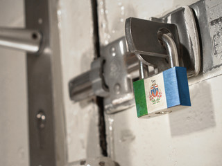 A bolted door secured by a padlock with the national flag of Yukon on it.(series)