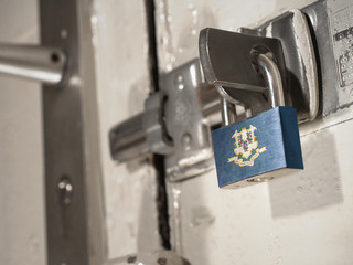 A bolted door secured by a padlock with the national flag of Connecticut on it.(series)