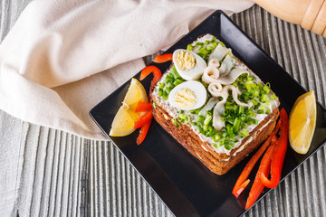 a huge herring sandwich with mayonnaise and quail eggs
