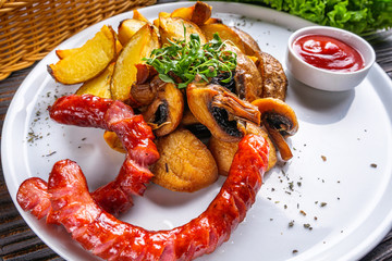 baked potatoes with sausages on a wooden rustic background