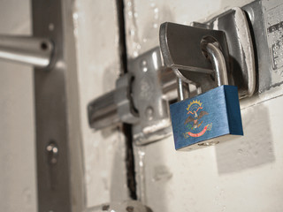 A bolted door secured by a padlock with the national flag of North Dakota on it.(series)