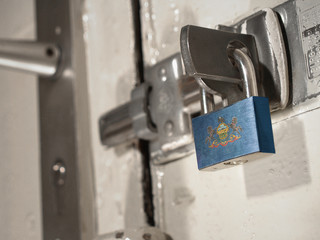 A bolted door secured by a padlock with the national flag of Pennsylvania on it.(series)