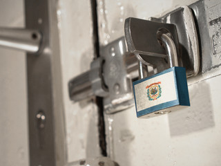 A bolted door secured by a padlock with the national flag of West Virginia on it.(series)