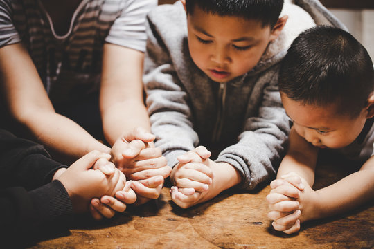 Mother And Children Praying And Praising God At Home