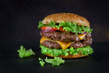 Burger with two beef patties and cheese on a dark background