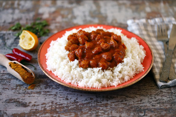 Vegan curry rice on a plate. White rice with curry with soy meat. Vegan lunch. Healthy food. Diet.