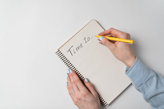 Time to Notice in notepad on white background. Words handwritten. Women's hands and Notebook on white background