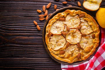 crispy apple galette with almonds on rustic wooden background