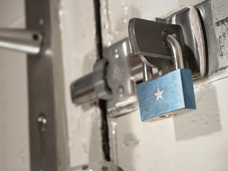 A bolted door secured by a padlock with the national flag of Somalia on it.(series)