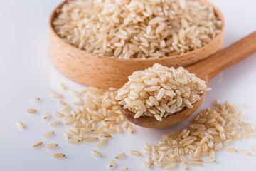 raw brown rice on white acrylic background