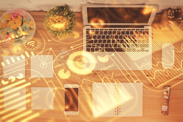 Technology hologram drawing over computer on the desktop background. Top view. Double exposure. Tech concept.