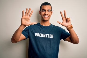 Young handsome african american man volunteering wearing t-shirt with volunteer message showing and...