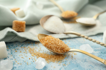 Spoons with sweet sugar on color background