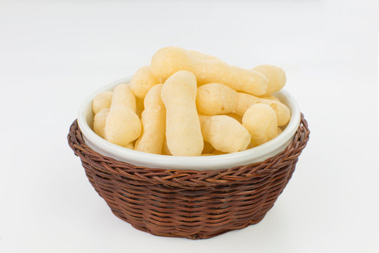 Traditional Brazilian starch biscuit called biscoito de polvilho in a basket isolated in white background