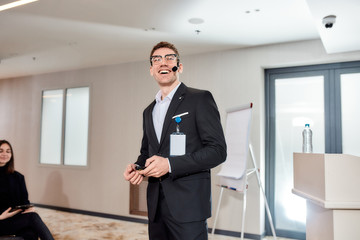 Pride and Performance. Young male caucasian speaker with headset and laser pointer smiling while...