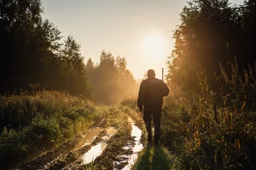  Silhouetted of a hunter with shotgun at beautiful sunset © romankosolapov