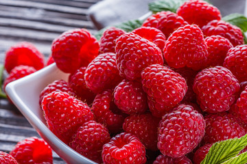 juicy fresh natural raspberries on a dark wooden rustic background