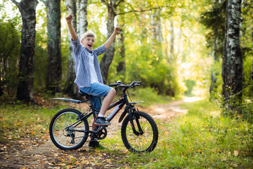 Fototapeta na wymiar Joyful boy on a bicycle with his parents in the park