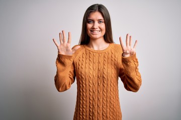 Young beautiful woman with blue eyes wearing casual sweater standing over white background showing...