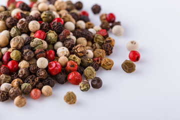 mix of peppercorns on white acrylic background