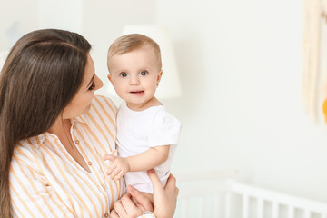 Happy mother with cute little baby at home
