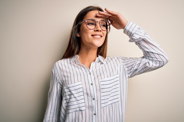Young beautiful brunette woman wearing casual shirt and glasses over white background very happy...