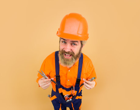 Builder man. Industrial worker with pliers. Pliers. Worker holds pliers. Repairment tools. Building. Builder in construction helmet. Hard hat. Repair. Industry. Technology.