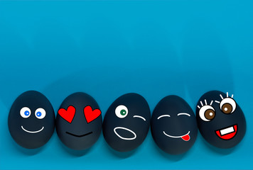 Easter eggs 5 pieces with the image of emojis, funny faces drawn isolated, on a blue background, flat lay. Easter and spring holiday concept. Copy space, top view.