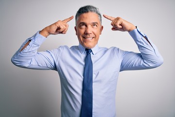 Middle age handsome grey-haired business man wearing elegant shirt and tie smiling pointing to head with both hands finger, great idea or thought, good memory