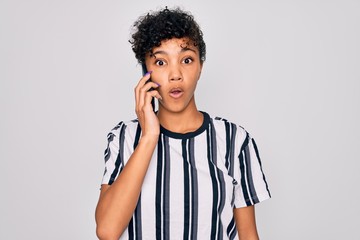 Young beautiful african american afro woman having conversation talking on the smartphone scared in shock with a surprise face, afraid and excited with fear expression