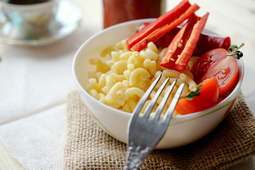 Appetizing pasta with chilli ketchup and fresh tomatoes. wooden table breakfast or lunch.