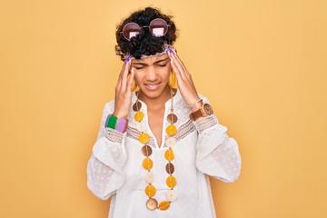 Young beautiful african american afro hippie woman wearing sunglasses and accessories with hand on headache because stress. Suffering migraine.