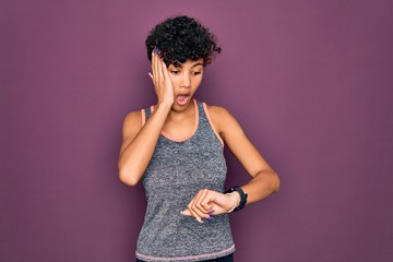 Young beautiful african american afro sportswoman doing exercise wearing sportswear Looking at the...