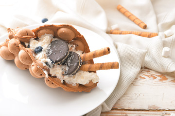 Plate with delicious sweet bubble waffle on table