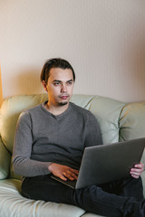 man typing on laptop working on freelance at home.