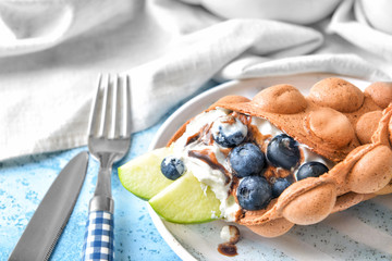 Plate with delicious sweet bubble waffle on table