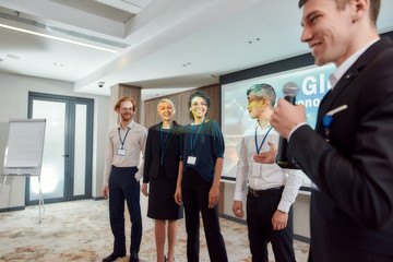 Fototapeta premium Portraits of Success. Cropped shot of young caucasian male speaker in suit presenting his colleagues while giving a talk at business meeting, economic forum