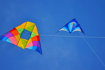 Two colorful kites flying in the blue sky