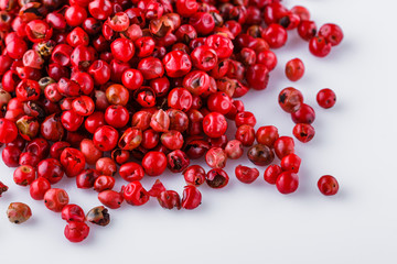 fragrant pink peppercorns on white acrylic background