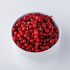 fragrant pink peppercorns on white acrylic background