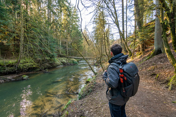 Hiking along a river in a ravine on sunny day