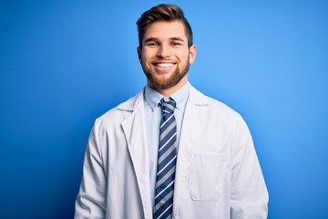 Young blond therapist man with beard and blue eyes wearing coat and tie over background with a happy and cool smile on face. Lucky person.