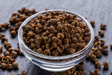 Sichuan pepper on a dark stone background